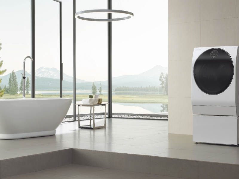 The LG Signature TWINWasg washer dryer stands in an open plan bathroom, overlooking verdant fields. Probably not a typical user case, but it looks stylish enough.
