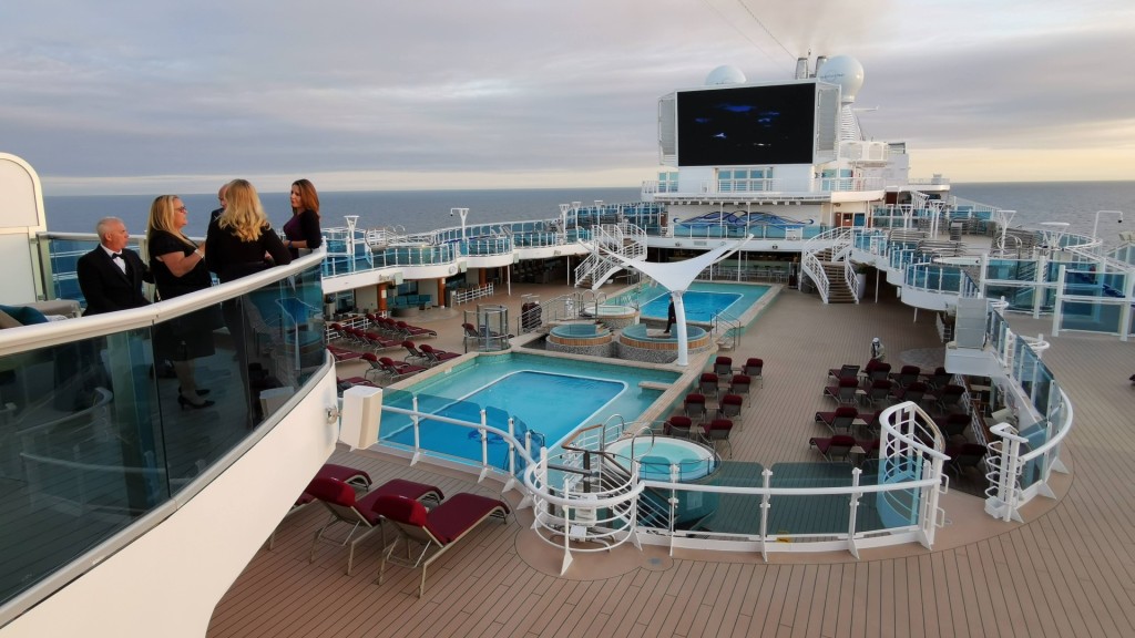 Black tie cruisers overlook the pool deck on Sky Princess