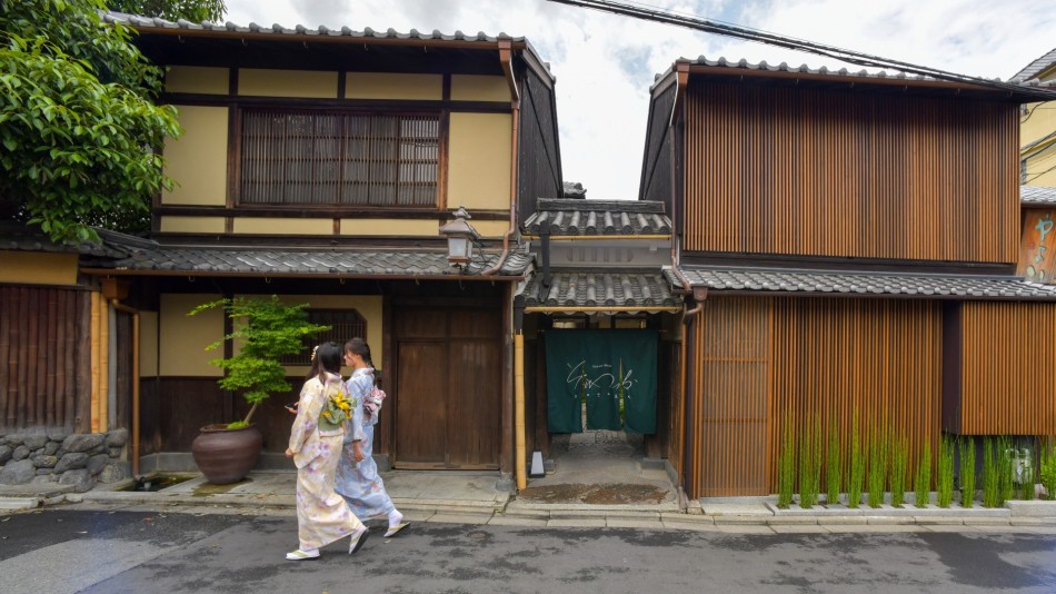 The exterior of the Kyoto Sowata hotel invites visitors to step back in time, here two geishas stroll past